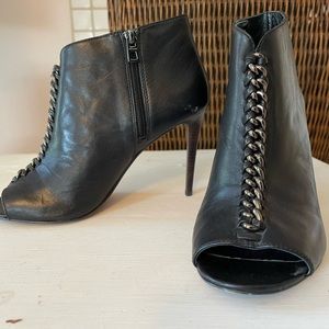 Lightly worn. Black leathe with silver chain. Open toe.